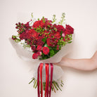 Granatina luxury bouquet — detail of garnet red baby roses against green foliage and white stock | Ecoroses Los Angeles