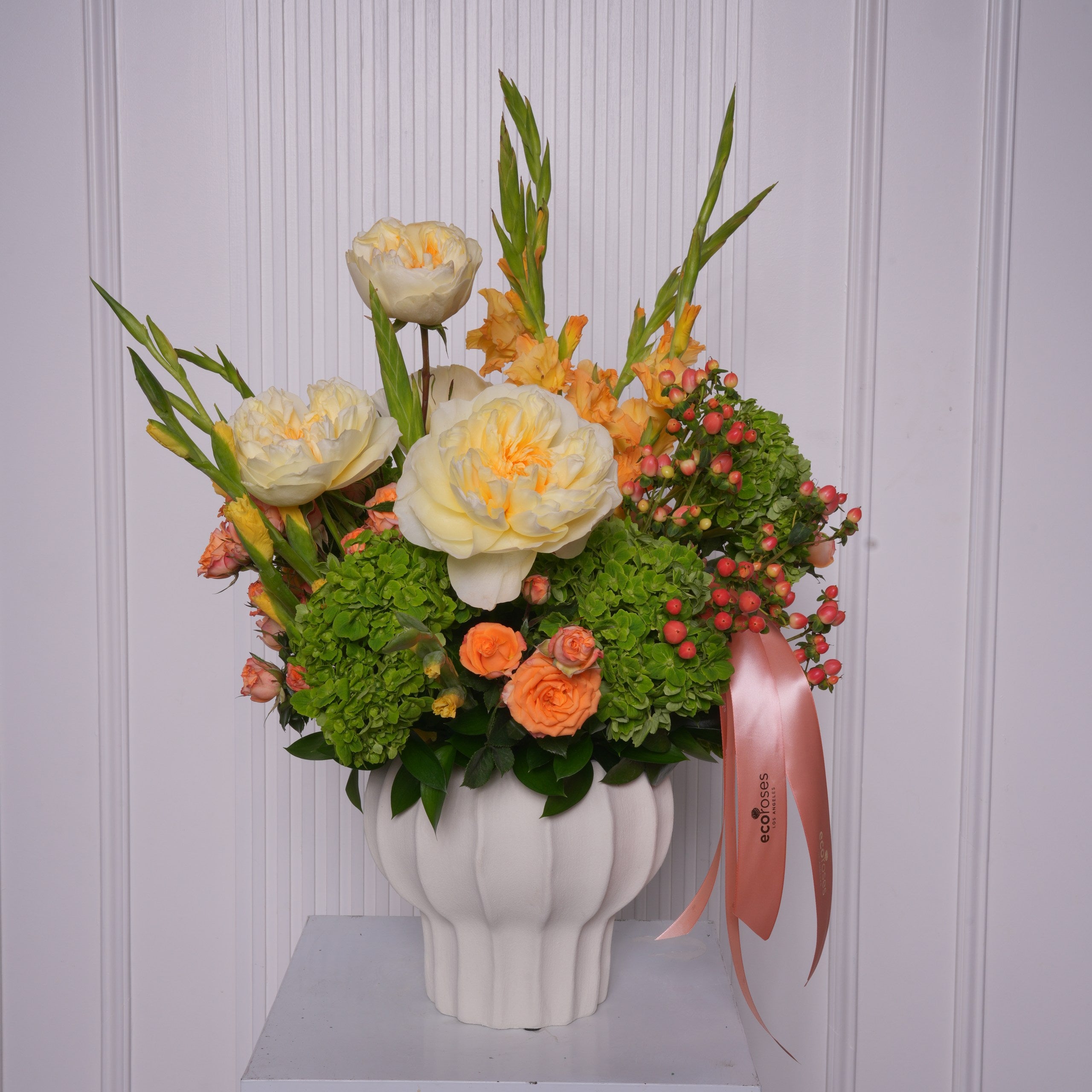 Livia couture arrangement — green hydrangea with cream garden roses, orange and yellow gladiolus, and orange baby roses in a glass vase | Ecoroses Los Angeles